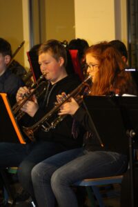 Schüler spielen Blasinstrumente bei einem Schulkonzert.