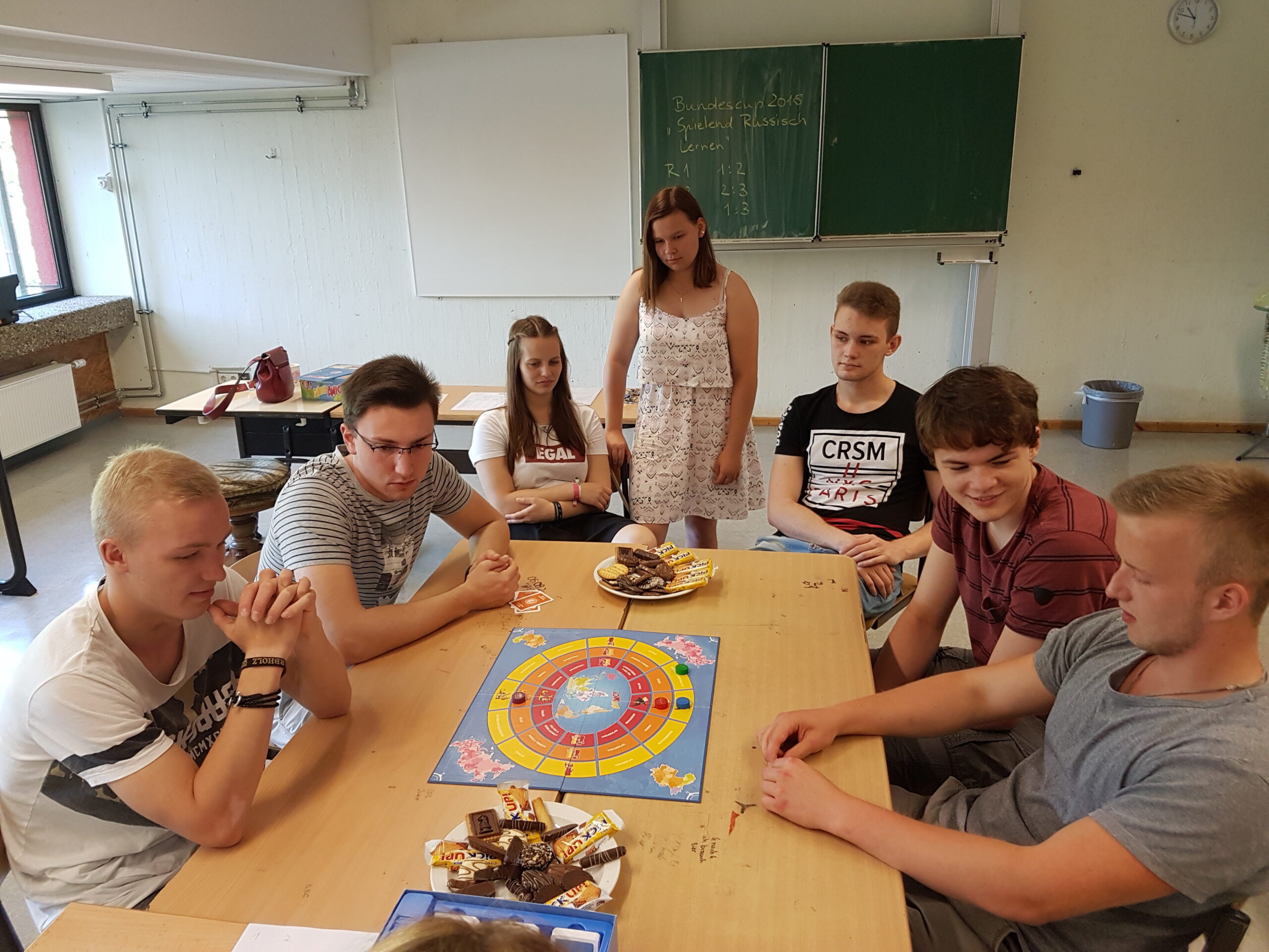 Schüler spielen ein Brettspiel in einem Klassenzimmer.