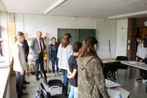 Schüler und Lehrer in einem Klassenzimmer während einer Besprechung.