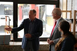 Besuch von Personen in einem Raum mit Fenster und Präsentation.