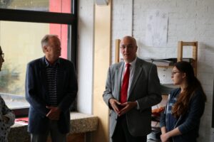 Besuch von vier Personen in einem Klassenraum, Redner im Vordergrund.