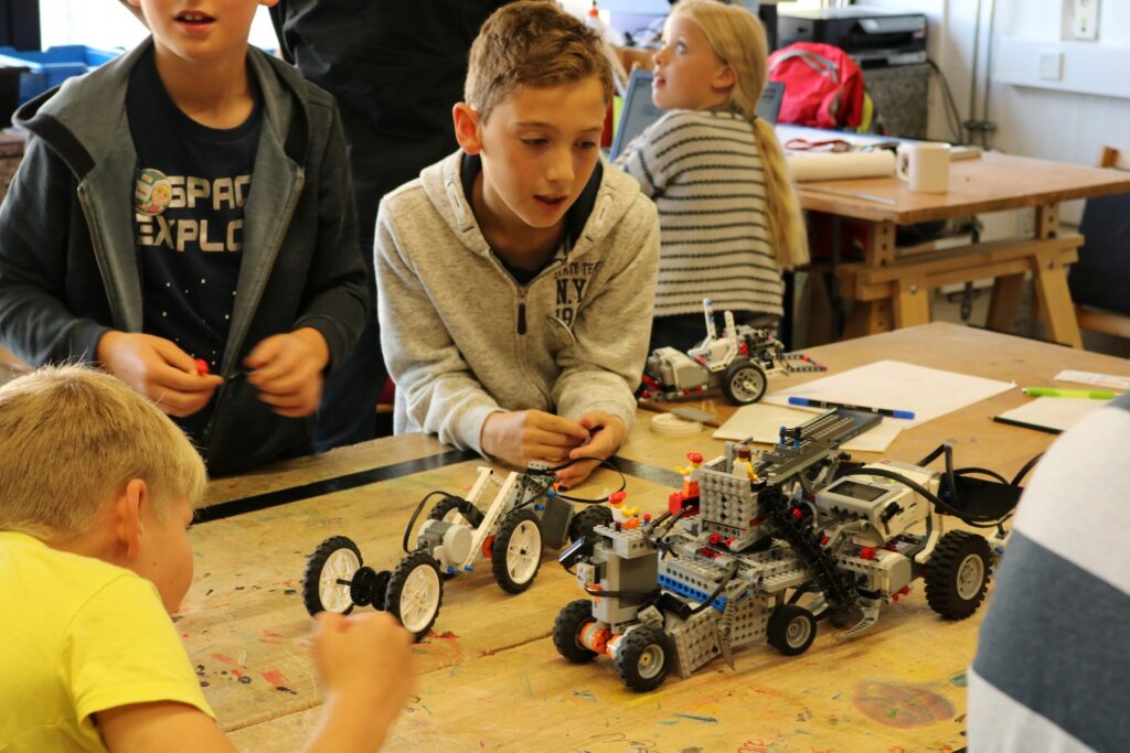 Kinder arbeiten an Lego-Robotern in einem Klassenraum.