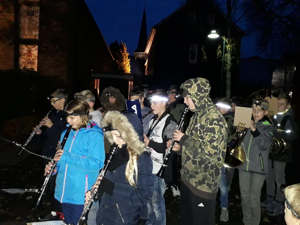 Musikgruppe mit Instrumenten bei Dämmerlicht auf der Straße.
