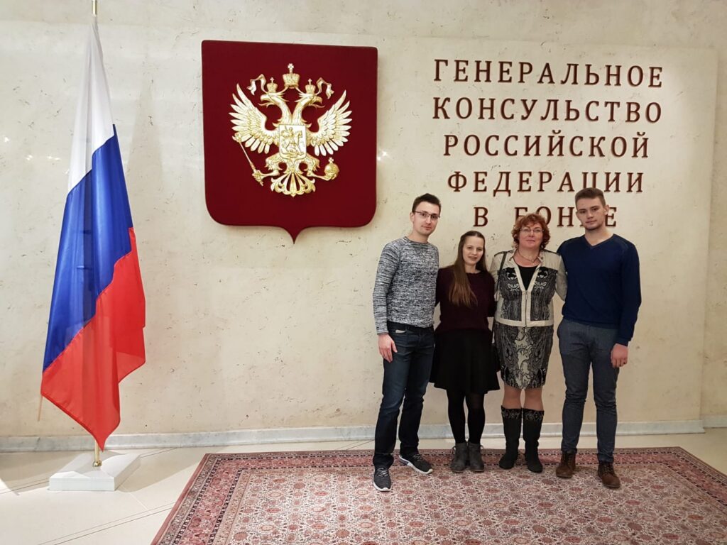 Menschen stehen vor dem russischen Konsulat in London, mit Flagge und Wappen im Hintergrund.