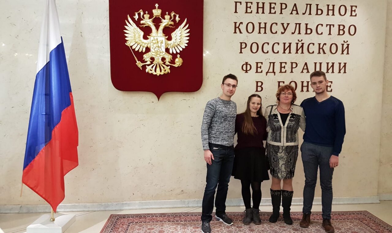 Menschen stehen vor dem russischen Konsulat in London, mit Flagge und Wappen im Hintergrund.