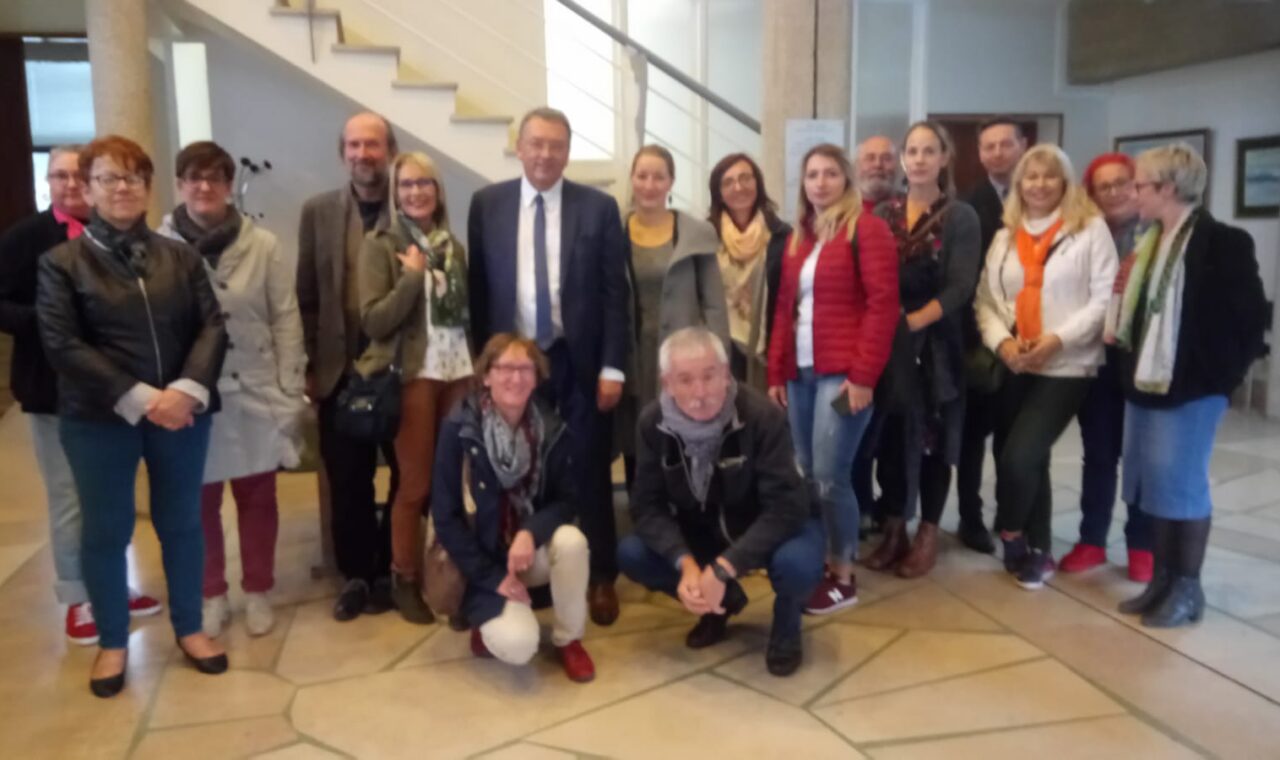 Gruppe von Menschen posiert in einem Gebäude, einige lächeln für das Foto.