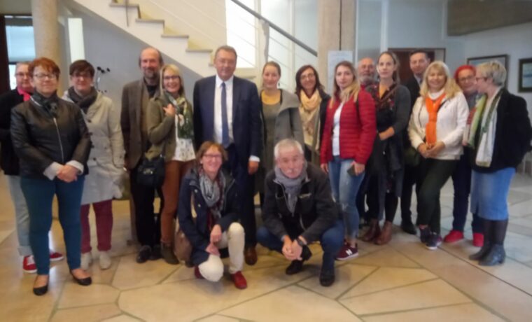 Gruppe von Menschen posiert in einem Gebäude, einige lächeln für das Foto.