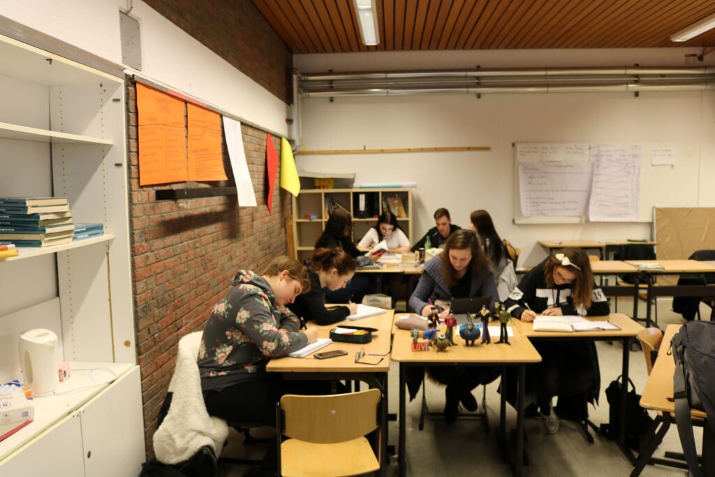 Schüler arbeiten konzentriert an Tischen in einem Klassenraum.