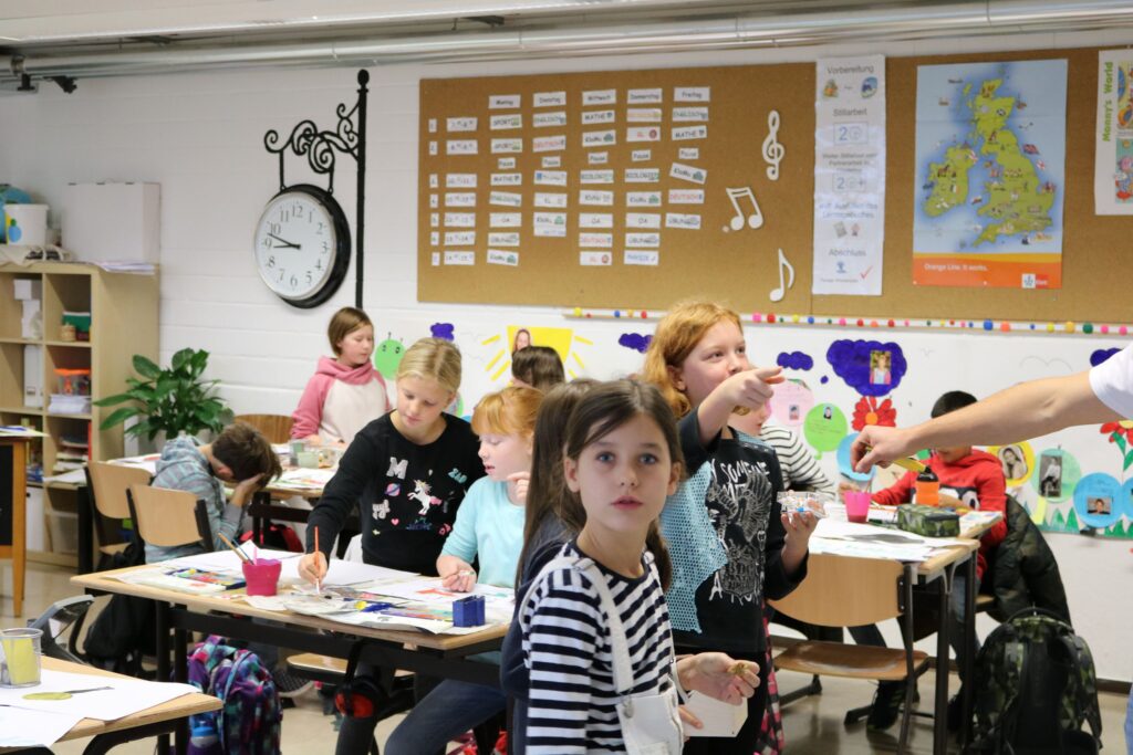 Schüler arbeiten in einem Klassenraum an verschiedenen Projekten.