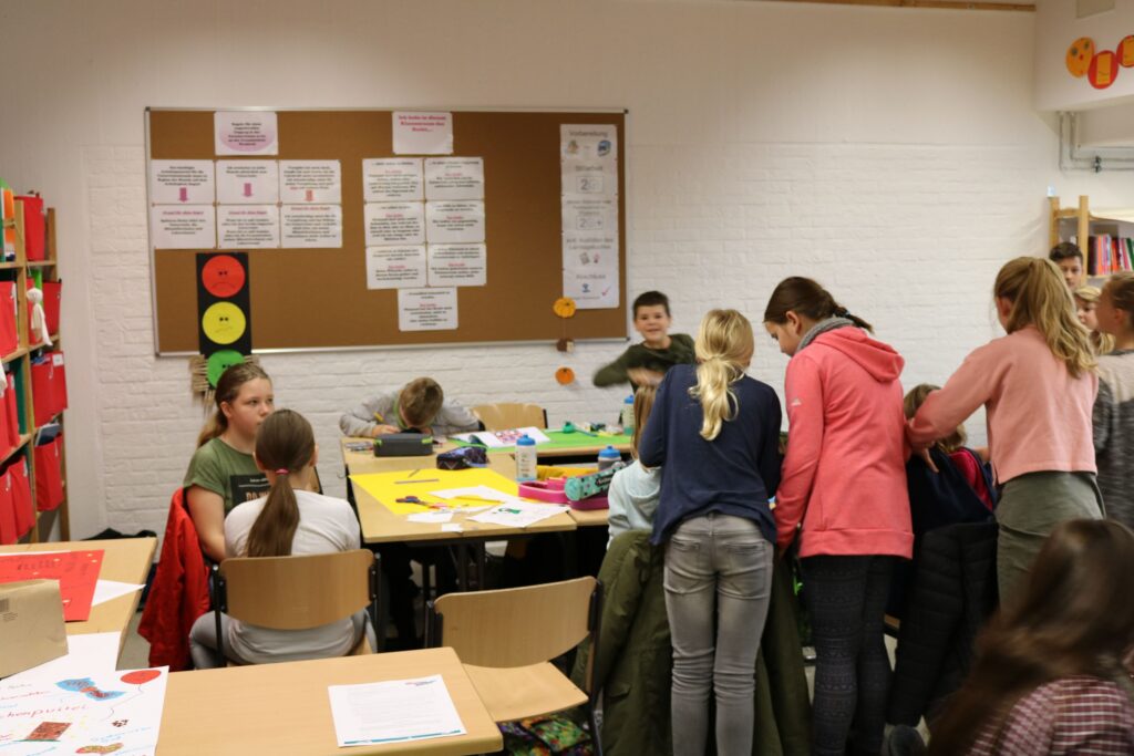 Schüler arbeiten konzentriert an einem Tisch in einem Klassenraum.