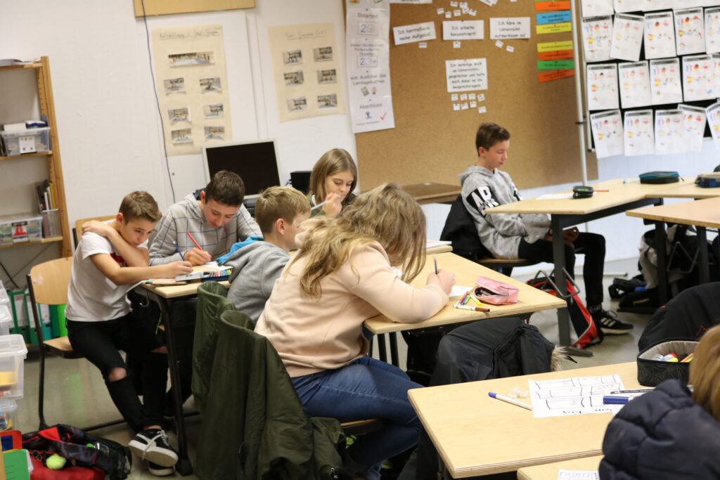 Schülerinnen und Schüler arbeiten konzentriert in einem Klassenraum.