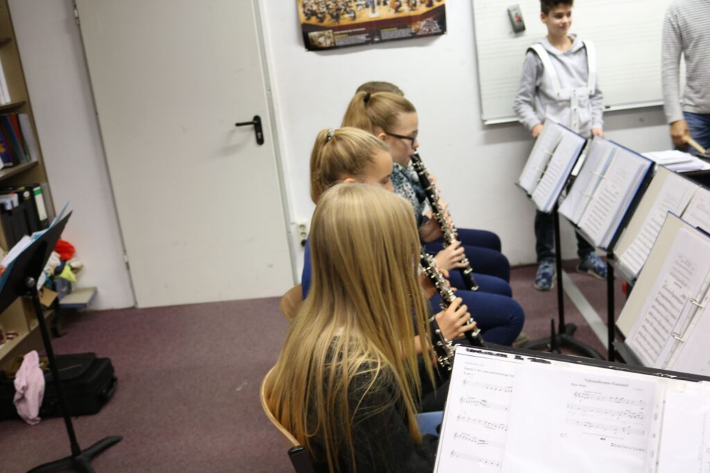 Schüler spielen verschiedene Holzblasinstrumente in einem Musikraum.