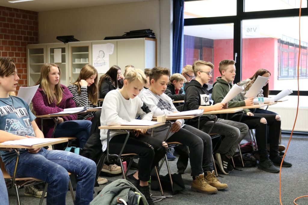 Schüler sitzen in einem Klassenraum und arbeiten an ihren Aufgaben.