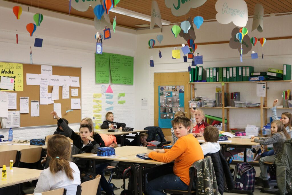 Schülerinnen und Schüler sitzen in einem Klassenzimmer mit dekorativen Elementen.