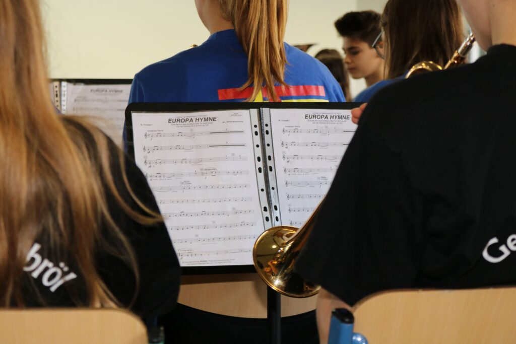 Schüler spielen in einer Blaskapelle, Notenblätter sind sichtbar.