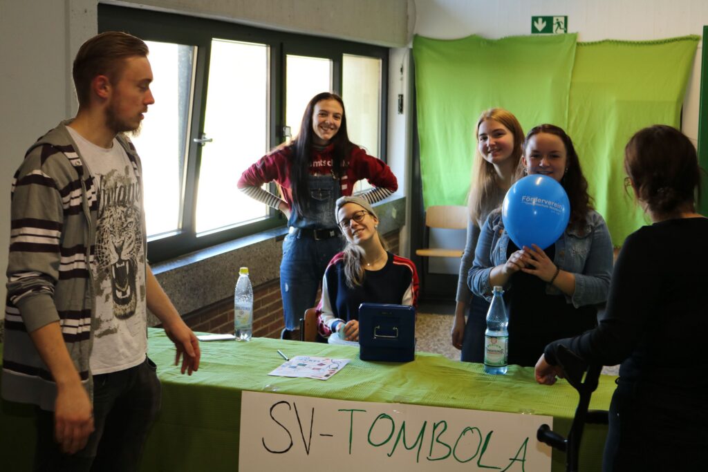 Schülerinnen und Schüler an einem Stand für die SV-Tombola mit Dekoration.