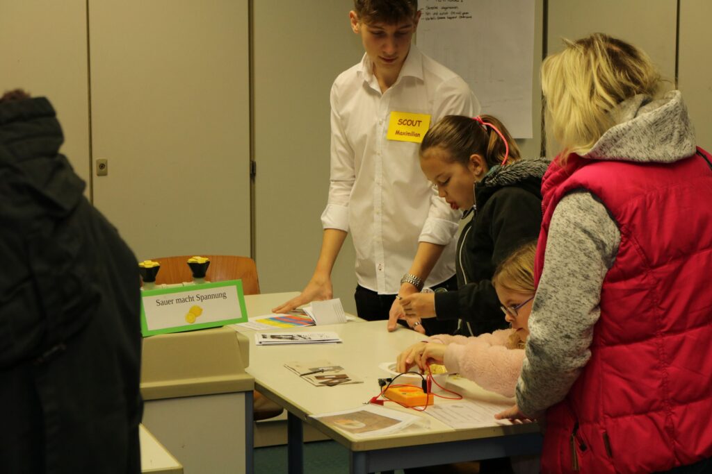 Schüler arbeiten an einem Tisch, diskutieren und schreiben.
