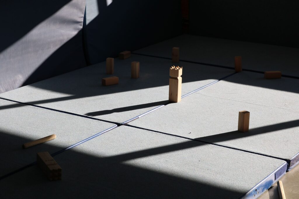 Spielmatte mit Holzklötzen in unterschiedlicher Anordnung und Schattenspielen.