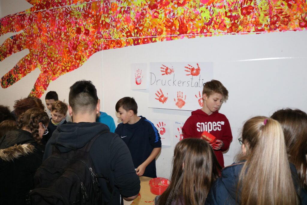 Schülerinnen und Schüler nehmen an einer Veranstaltung mit handgemachten Kunstwerken teil.
