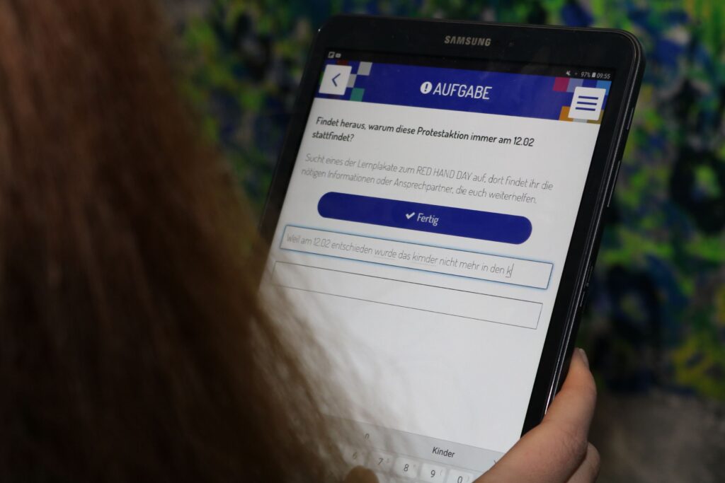 Junge Person nutzt ein Tablet mit einer Online-Anwendung.
