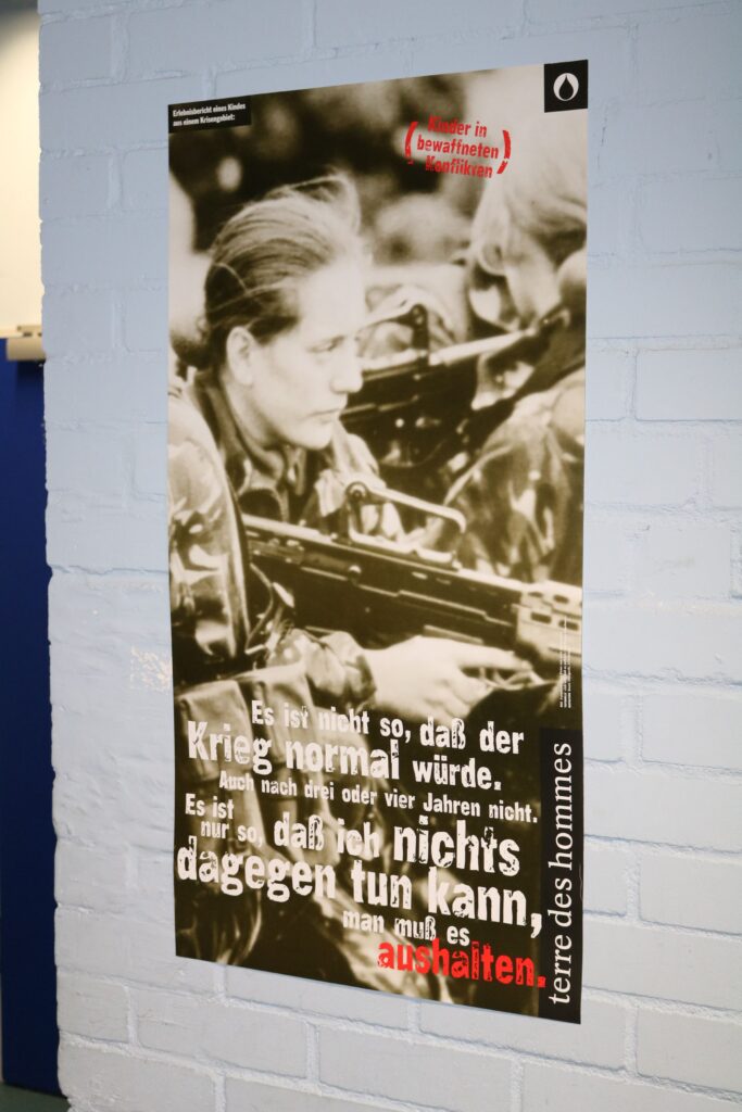 Plakat mit Soldatin und dem Text über Krieg und Aktivismus.