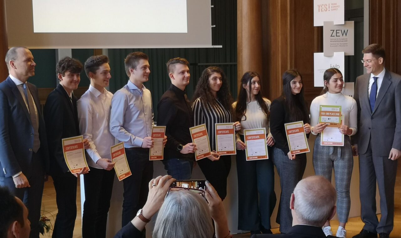 Gruppe von Personen mit Urkunden auf einer Veranstaltung.