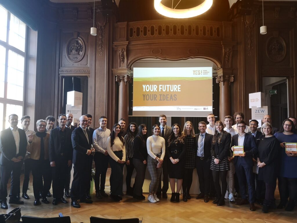 Gruppenfoto von Teilnehmern einer Veranstaltung in einem historischen Saal.