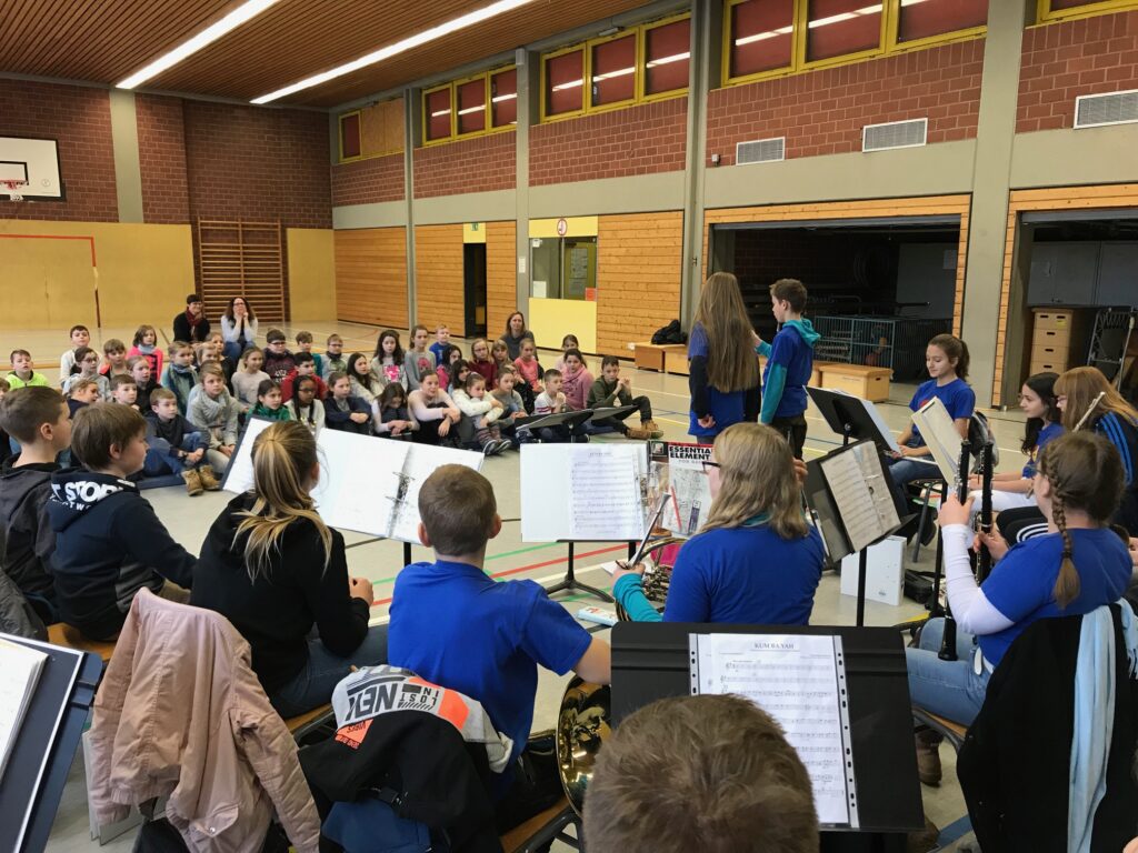 Schülerinnen und Schüler in einem Musikraum, die ein Konzert beobachten.