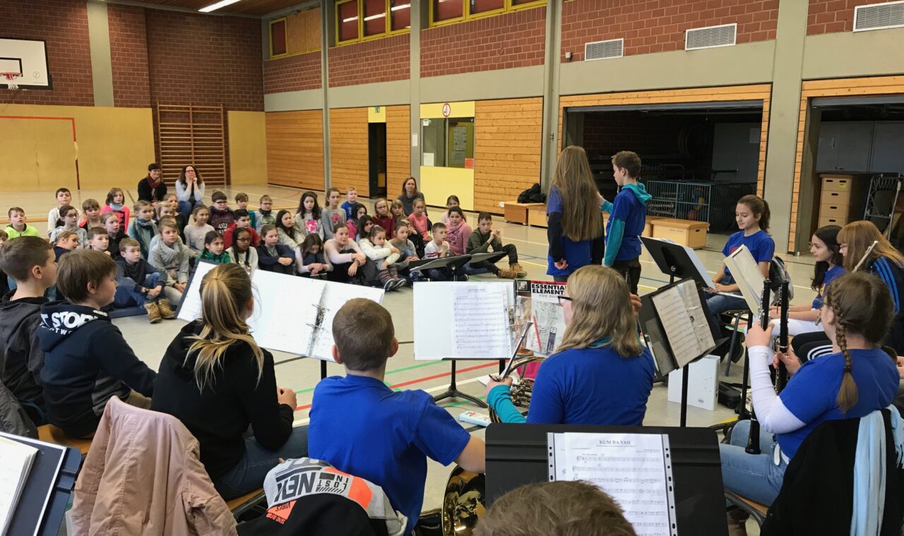 Schülerinnen und Schüler in einem Musikraum, die ein Konzert beobachten.