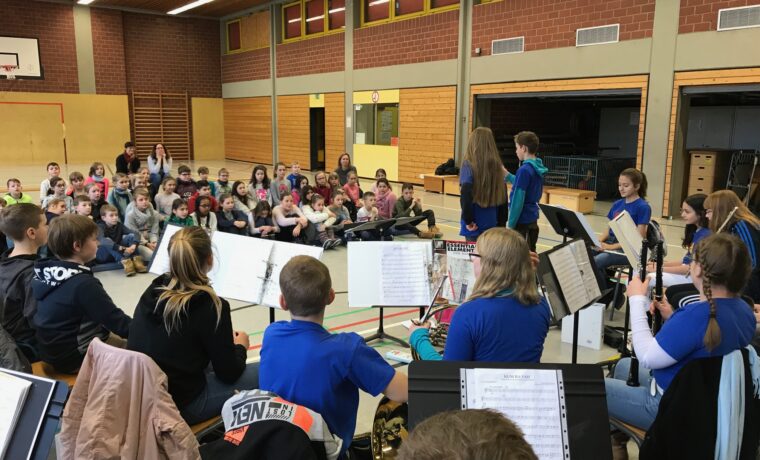 Schülerinnen und Schüler in einem Musikraum, die ein Konzert beobachten.