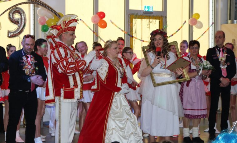 Karnevalsveranstaltung mit costümierten Personen und Tänzern im Hintergrund.