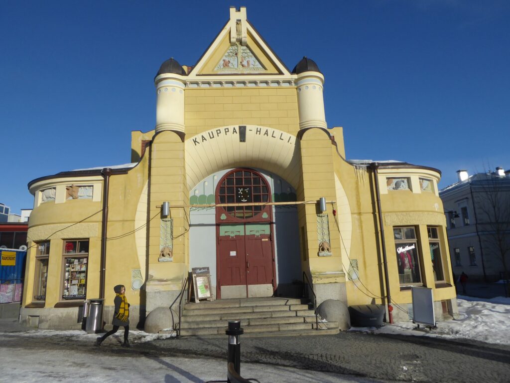Historisches, gelbes Gebäude mit Rundbogenfenstern und Eingangsportal.