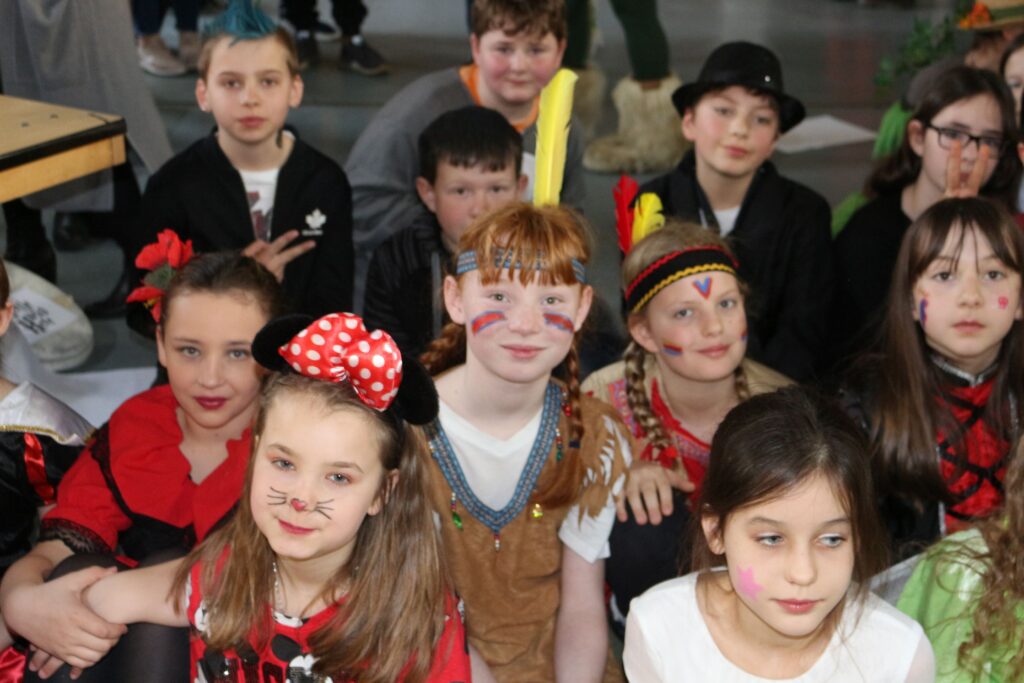Eine Gruppe von Kindern in Kostümen feiert zusammen.