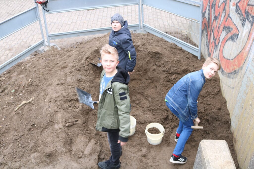 Kinder graben in einem befestigten Bereich.