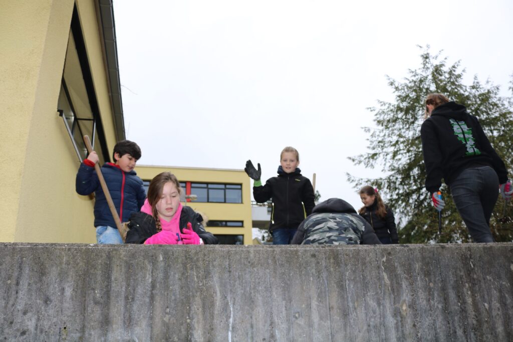 Schüler arbeiten draußen und engagieren sich in einer Aktivität.