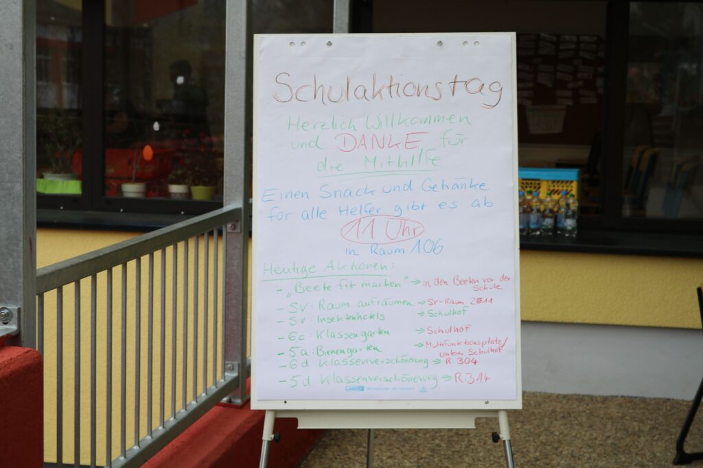 Ein aufgestelltes Plakat mit Informationen zum Schulfest und Veranstaltungen.