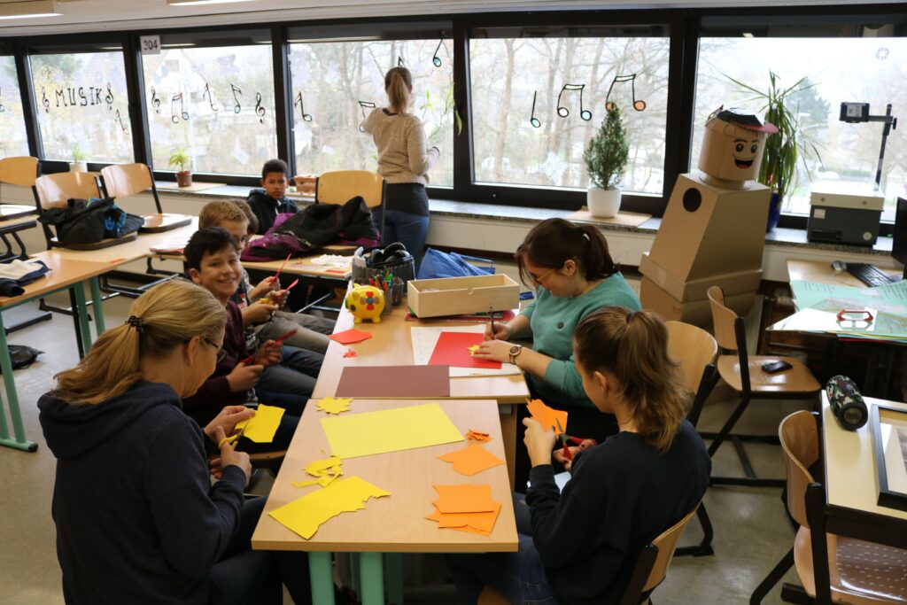 Schüler arbeiten an Bastelprojekten in einem Klassenzimmer.