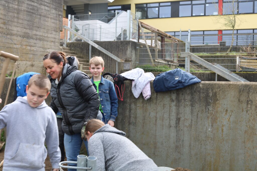 Schüler und Lehrer arbeiten gemeinsam im Freien an einem Projekt.