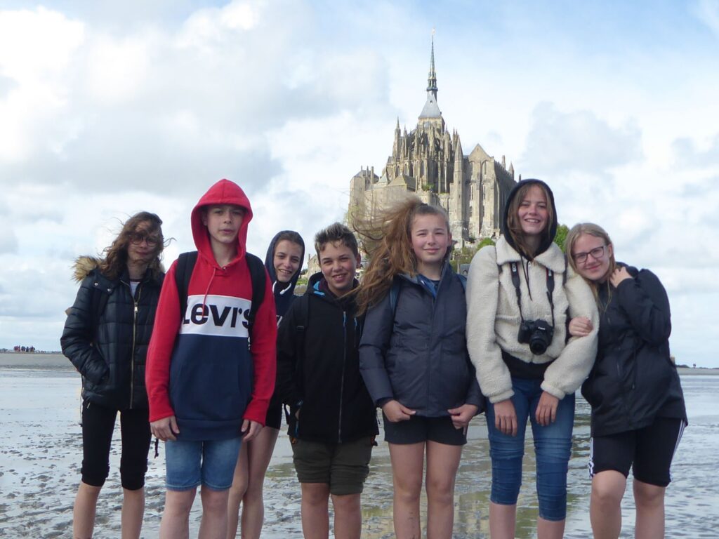 Schülergruppe vor Mont Saint-Michel bei niedrigem Wasserstand.