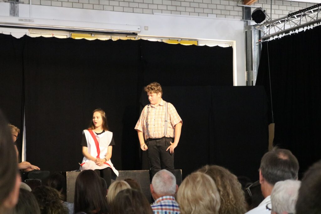 Schauspieler auf der Bühne während einer Aufführung in einer Schule.