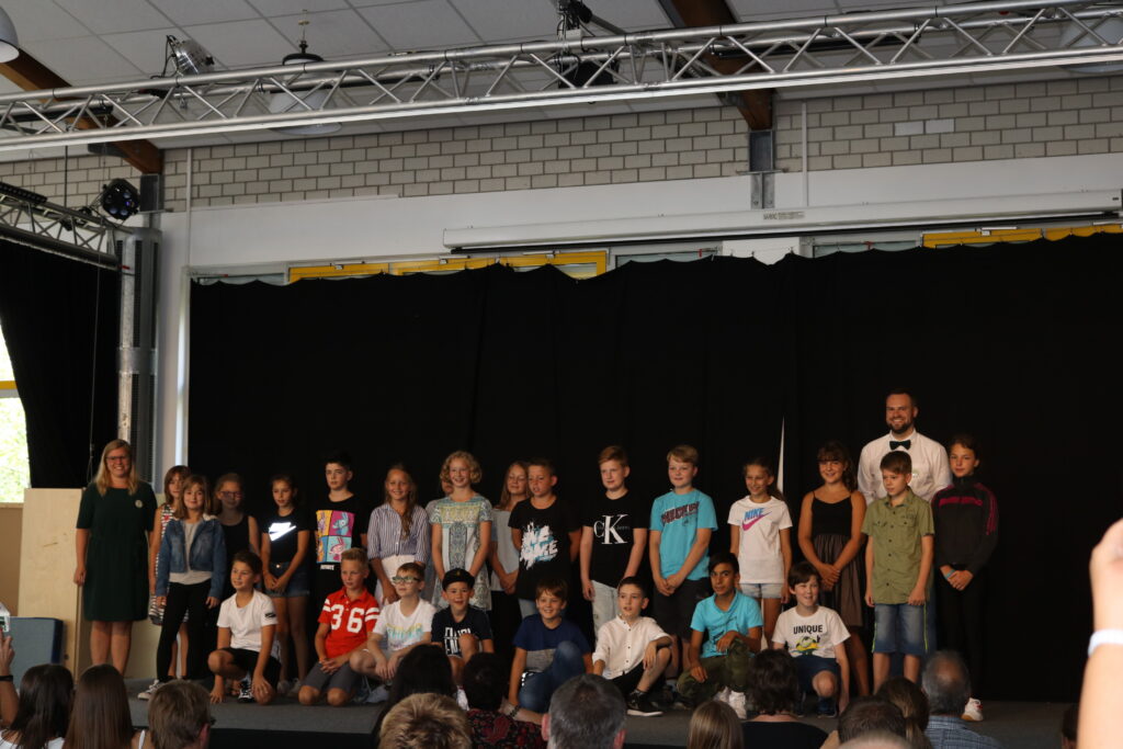 Schüler stehen auf einer Bühne bei einer Veranstaltung in der Schule.
