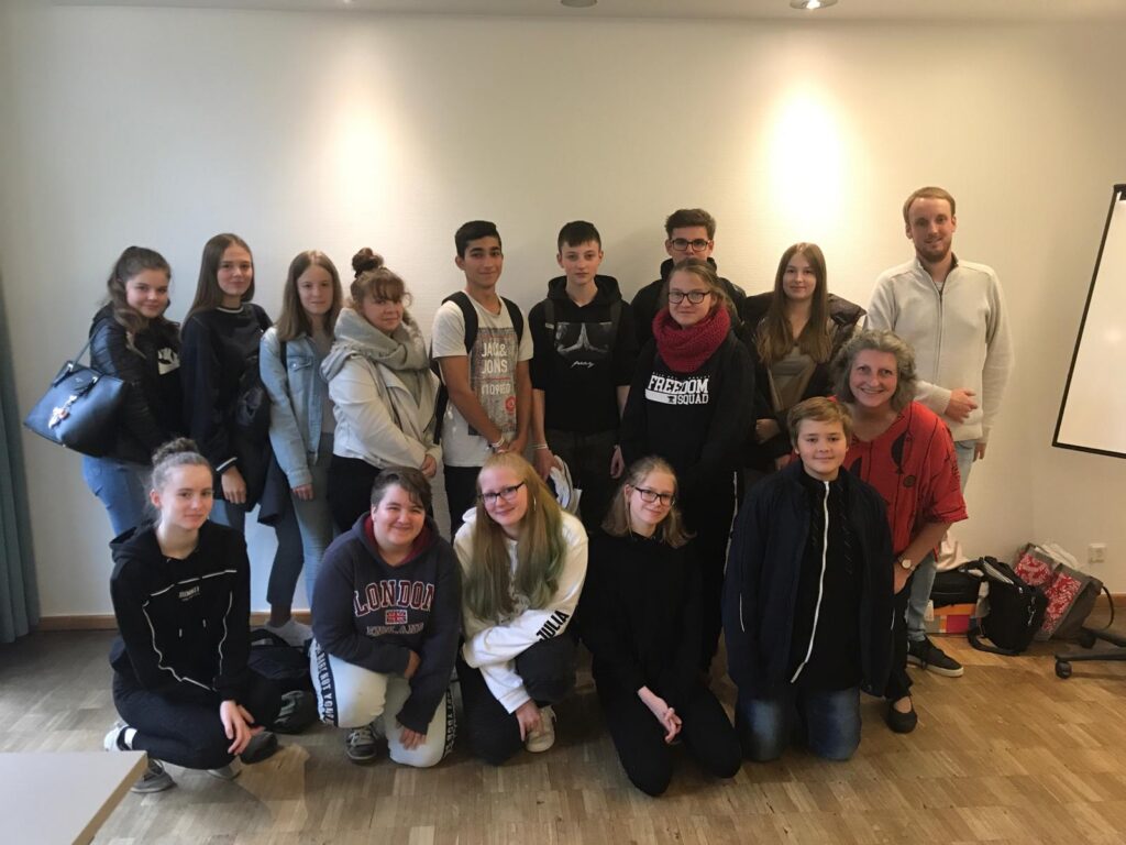 Gruppe von Schülerinnen und Schülern posiert gemeinsam in einem Raum.