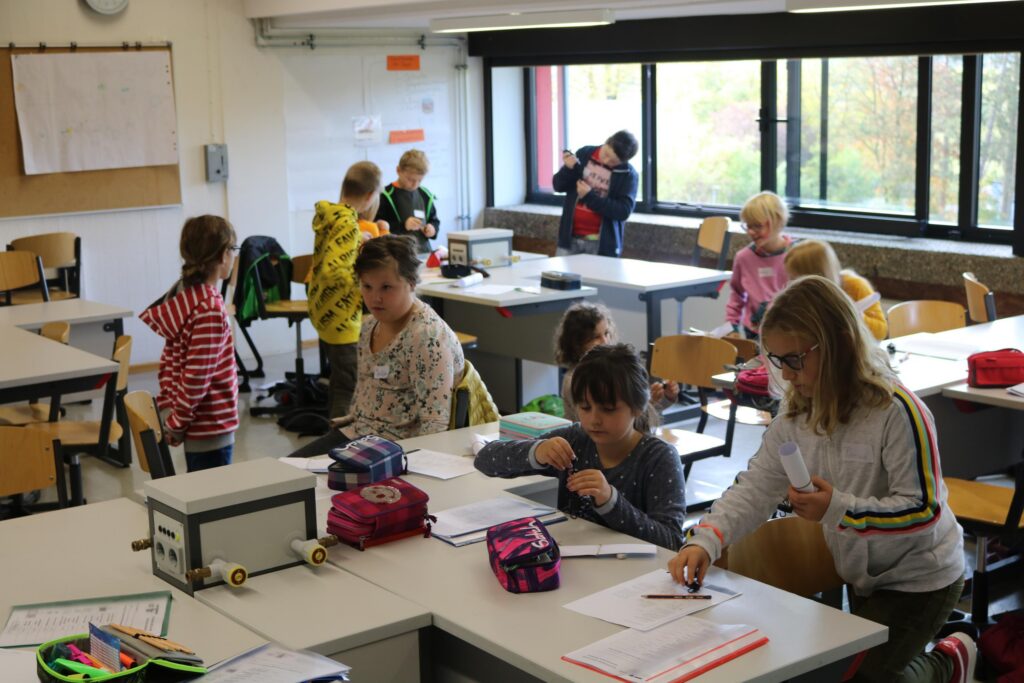 Schüler arbeiten in einem Klassenzimmer an Schreibtischen.