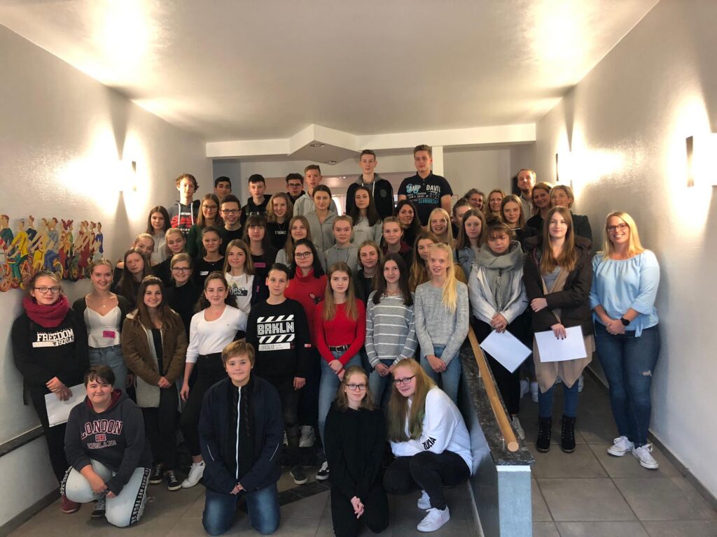 Gruppenfoto von Schülern und Lehrern in einem Flur.