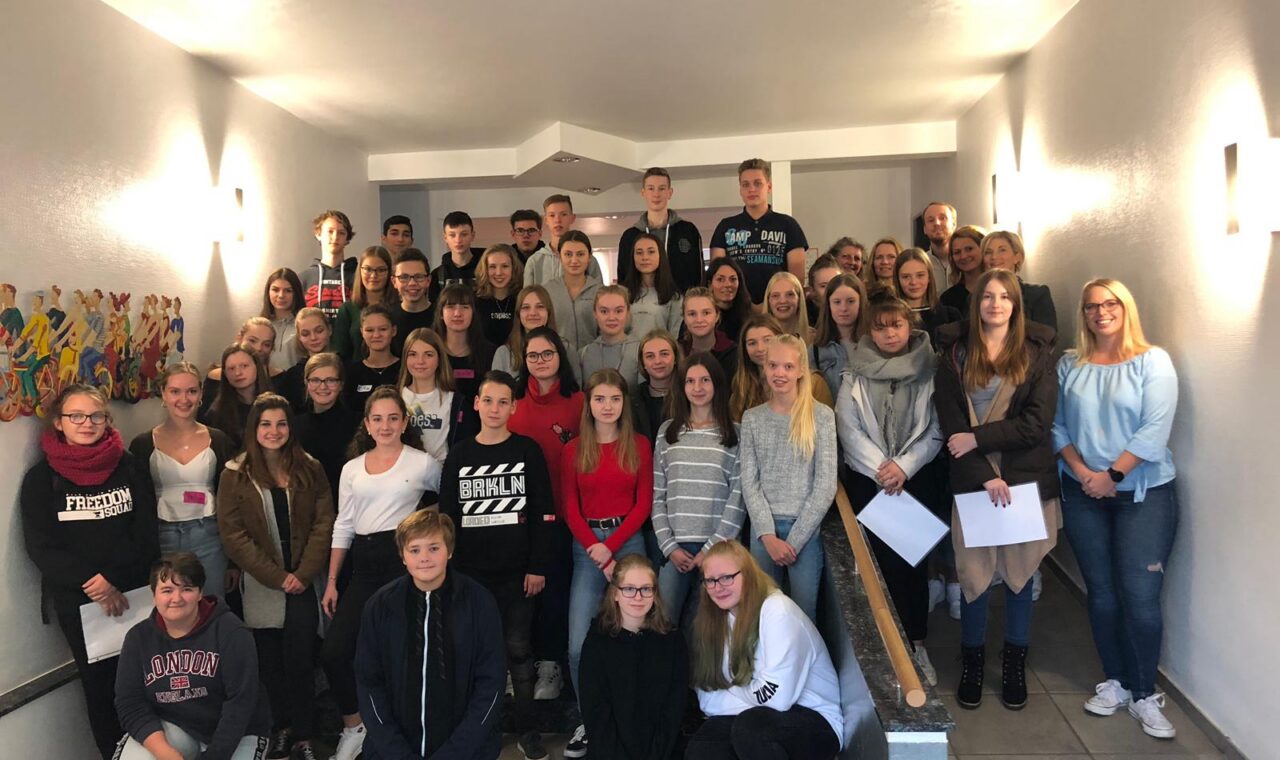 Gruppenfoto von Schülern und Lehrern in einem Flur.