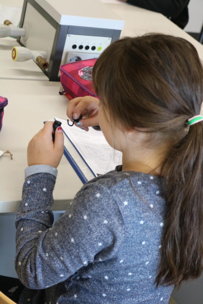 Ein Mädchen arbeitet an einem Tisch mit Schulsachen.