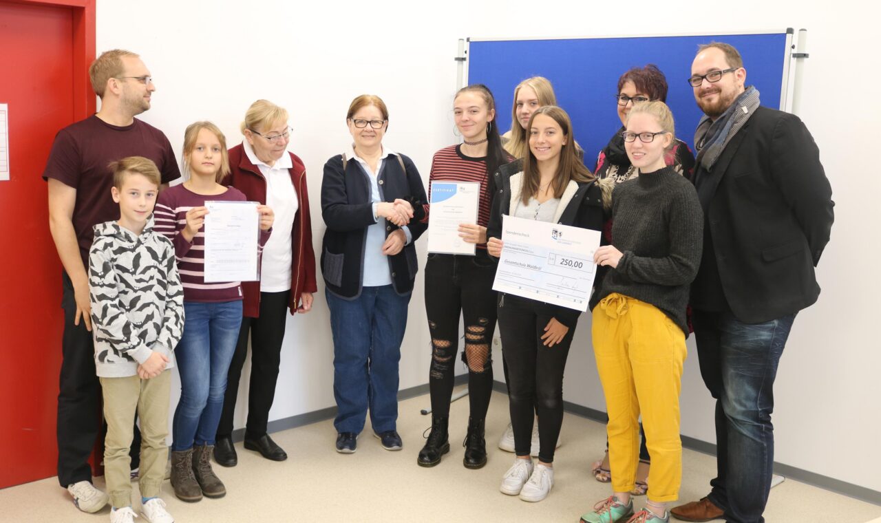 Gruppe von Schülerinnen, Lehrern und Eltern bei einer Auszeichnung.