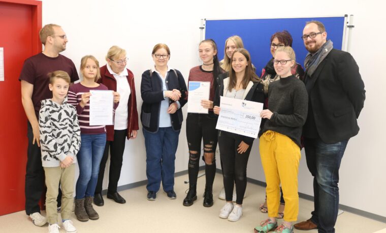 Gruppe von Schülerinnen, Lehrern und Eltern bei einer Auszeichnung.