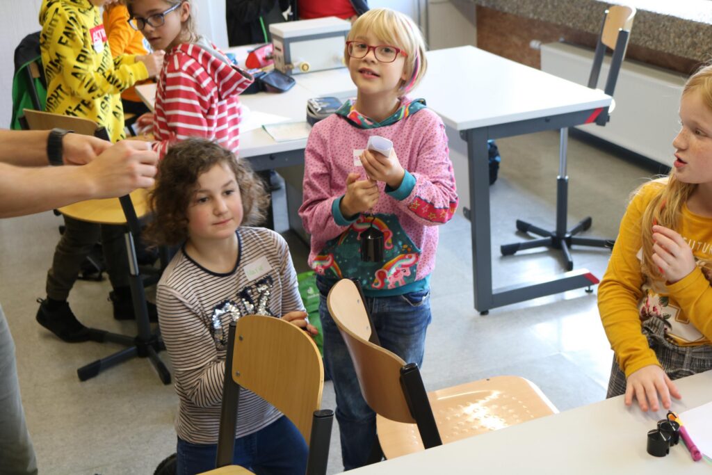 Kinder sitzen in einem Klassenzimmer und beobachten aufmerksam.