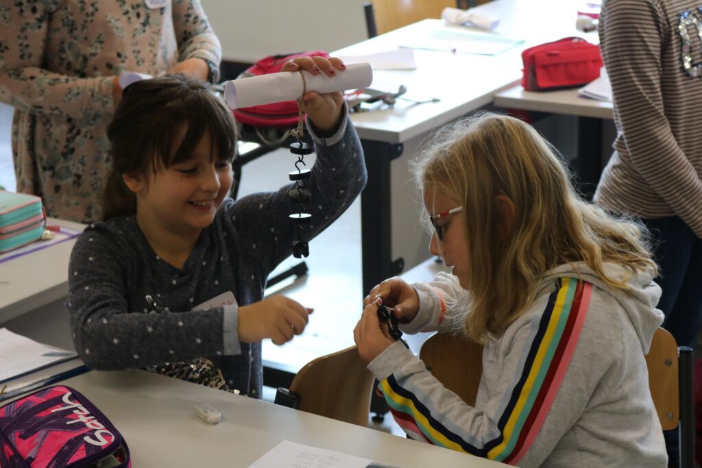 Zwei Schülerinnen experimentieren gemeinsam am Tisch im Klassenraum.